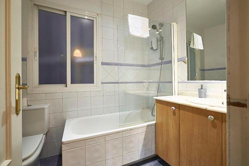 uma casa de banho com uma banheira, um WC e um lavatório. em Santo Domingo Rooms em Madri