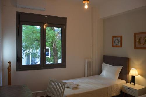 Schlafzimmer mit einem Bett und einem Fenster in der Unterkunft Cozy and comfortable apartment in Athens Center in Athen