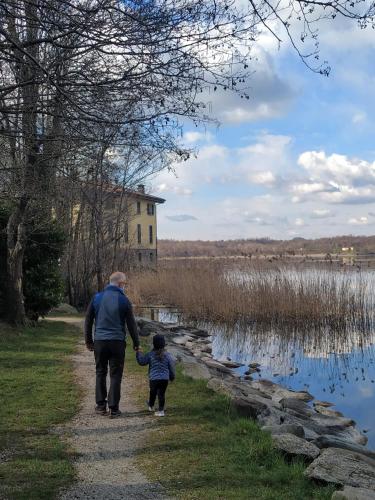 a man and a child walking down a path next to a lake at Casa Castel in Civate