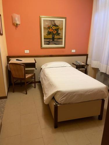 a bedroom with a bed and a table and a desk at Bes Hotel Papa San Pellegrino Terme in San Pellegrino Terme