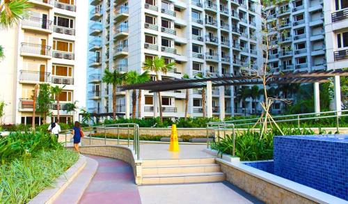 a woman walking down a walkway in front of a building at Solemare Parksuites Condo in Manila