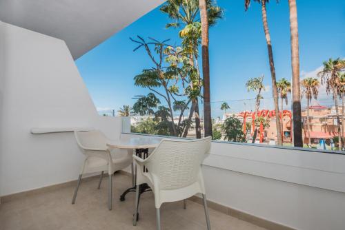 a dining room with a table and chairs and a large window at Iberostar Waves Las Dalias All Inclusive in Adeje