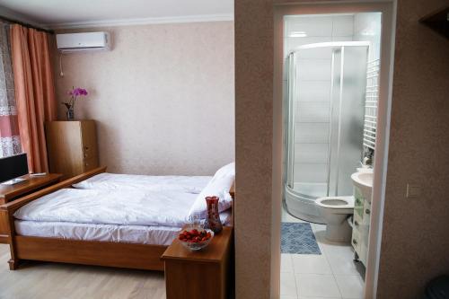 a bedroom with a bed and a bathroom with a shower at Sweet Home Hostel in Chernivtsi