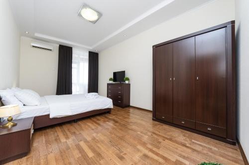 a bedroom with a large bed and a large cabinet at VIP New House Arena City in Kyiv