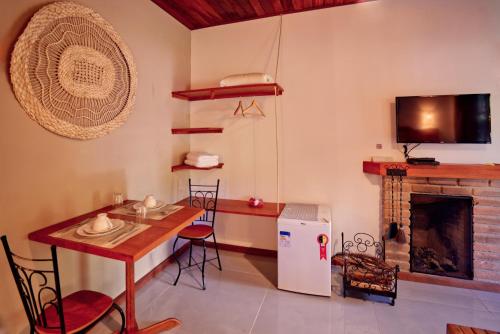 a living room with a table and a fireplace at Verde da Mantiqueira Chalés in Visconde De Maua