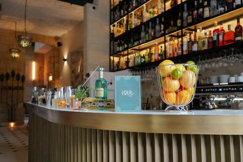 - un bar avec un bol de fruits sur un comptoir dans l'établissement LOLA Boutique Hôtel - Bordeaux Centre, à Bordeaux