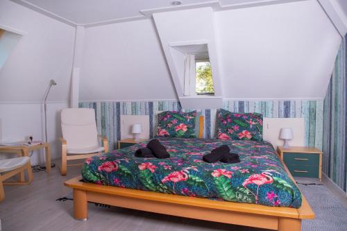 a bedroom with a bed with a floral bedspread at B en B 't Pekeltje in Medemblik