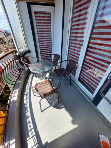 a balcony with a glass table and chairs on it at Petreski Apartments 1 in Ohrid