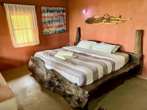 a bedroom with a bed made out of a log at Nemasu Eco-lodge in Gunjur