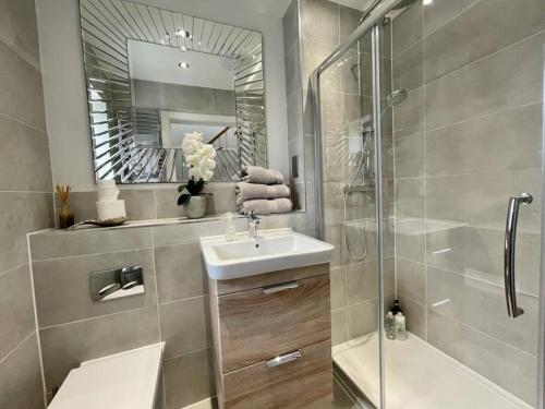 une salle de bain avec un lavabo, une douche et un miroir dans l'établissement Whitstable - Salt Yard Cottage 4, à Whitstable