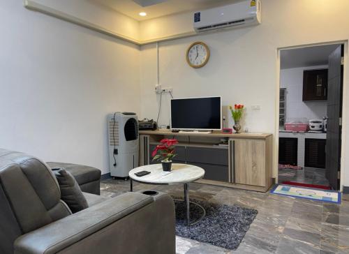 - un salon avec un canapé, une télévision et une table dans l'établissement Pimmada@Khao Yai, à Ban Khanong Phra Klang (1)