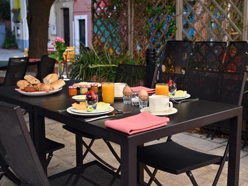 una mesa negra con comida y pan. en L'Hostalet, en Argelès-sur-Mer