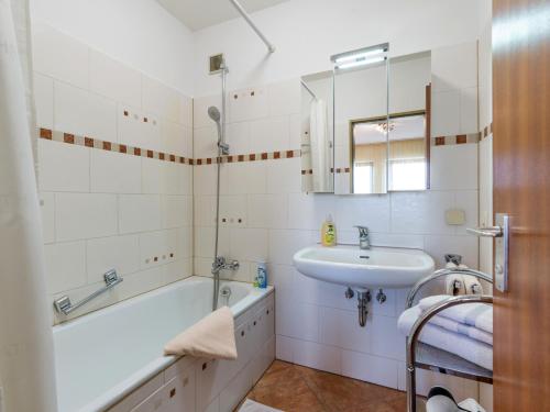 a bathroom with a sink and a bath tub and a sink at Ferienwohnanlage Bergschlößl Wohnung Nr 9 in Oberaudorf