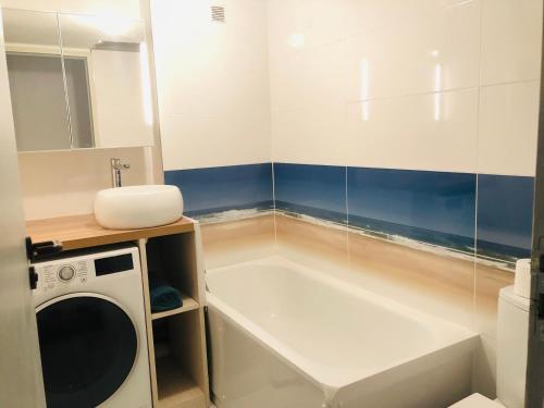 y baño con lavadora y lavamanos. en Lacanau Ocean : Maison de vacances dans la Pinede, en Lacanau