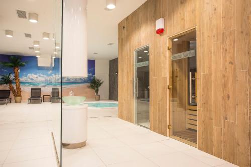 Focus Hotel Premium Lublin Conference & SPA في لوبلين: حمام بباب زجاجي وحوض استحمام