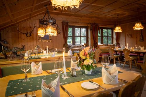 a dining room with tables and chairs and chandeliers at Schmelmer Hof Hotel & Resort in Bad Aibling