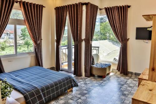 a bedroom with a bed and a large window at villa Trung Nghĩa 5 in Da Lat