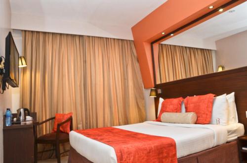a hotel room with a bed and a mirror at Hotel Rio in Nairobi