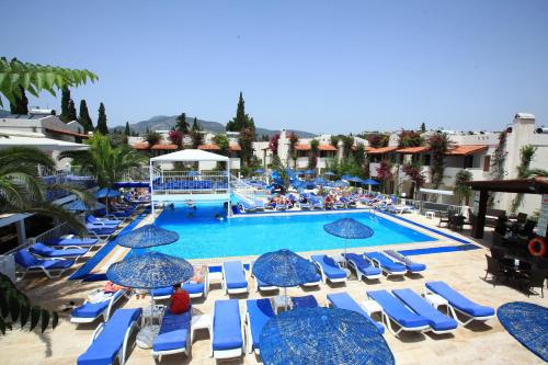 a large swimming pool with blue chairs and umbrellas at Summer Garden Suites Beach Hotel in Bitez