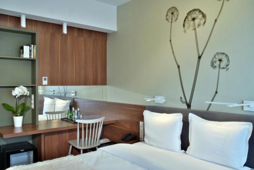 a bedroom with a bed and a desk with a chair at Focus Hotel Premium Lublin Conference & SPA in Lublin