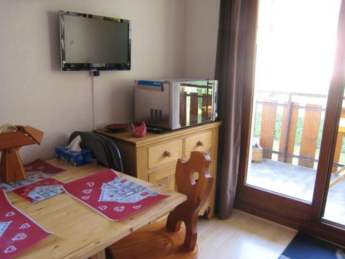 a dining room with a table and a tv on a cabinet at Appartement d'une chambre a Bernex a 50 m des pistes avec balcon et wifi in Bernex