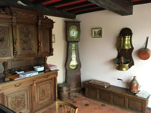 a room with a clock on the wall and a table at Maison de 7 chambres avec vue sur le lac jardin clos et wifi a Le Dezert in Montmartin-en-Graignes