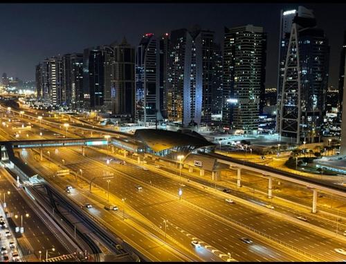 a city at night with cars on a highway at Luxury Room with Marina view close to JBR Beach and Metro with Shared Kitchen in Dubai