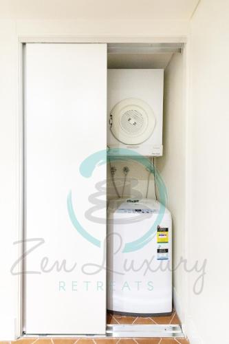 a small refrigerator in a corner of a room at ZEN AT THE ESPLANADE - Spectacular Sunset Retreat in Darwin