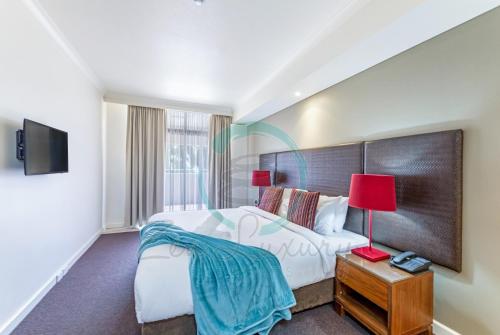 a hotel room with a bed and a tv at ZEN AT THE ESPLANADE - Spectacular Sunset Retreat in Darwin