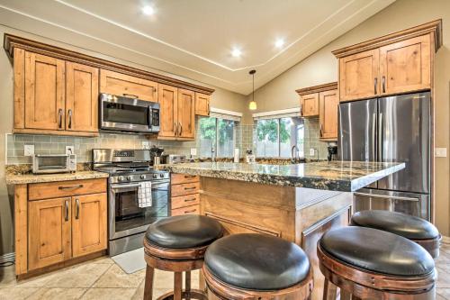 una cucina con mobili in legno e sgabelli da bar di Pool, Golf Course Views Desert Oasis in Glendale a Glendale