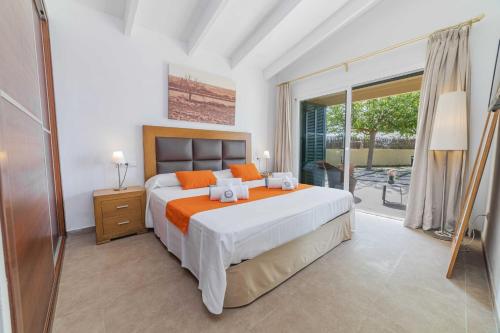 a bedroom with a large bed and a balcony at Villa Ambient / Sa Finqueta in Muro