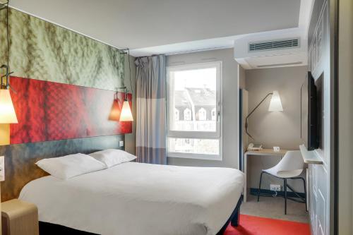 a hotel room with a white bed and a window at ibis Rueil-Malmaison Centre in Rueil-Malmaison