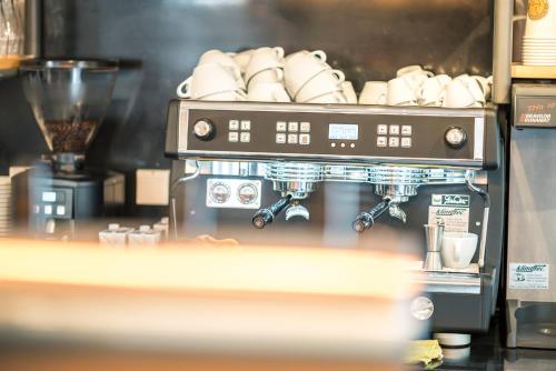 a coffee making machine with a bunch of cups at Stefanies-Café-Pension-Kultur in Bad Feilnbach