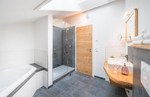 a bathroom with a shower and a sink and a tub at Stefanies-Café-Pension-Kultur in Bad Feilnbach