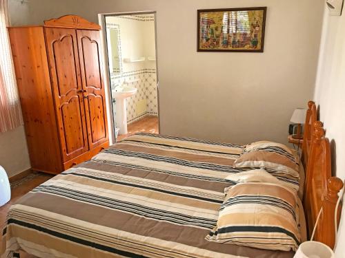 een bed in een slaapkamer met een houten bedframe bij BUGANVÍLEA - Vivenda johanna in Lagos