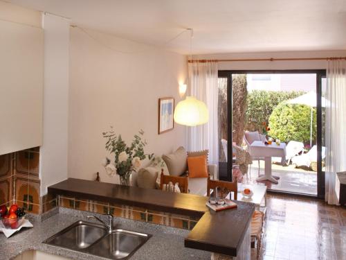 a kitchen with a sink and a living room at Casa adosada en Playa de Pals by Apartaments Golf in Pals