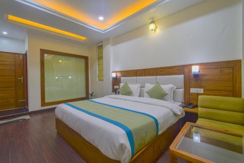 a bedroom with a large bed and a chair at Hotel The Paal in Shimla
