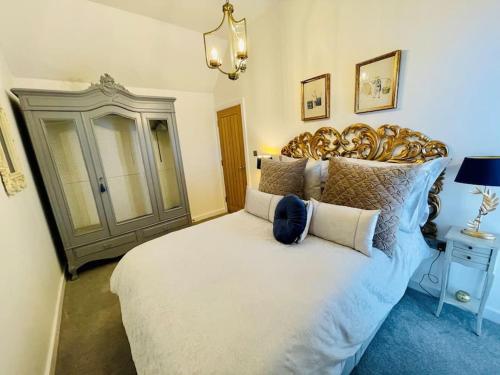 a bedroom with a large bed with a large headboard at Salt Yard Cottage No 2 in Whitstable