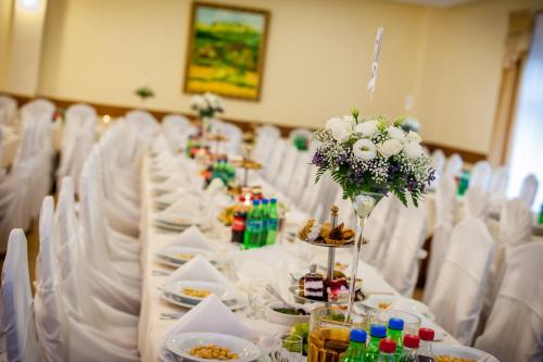 a long table with plates of food and flowers at Piastun SPA&Wellness Krynica-Zdrój in Krynica Zdrój
