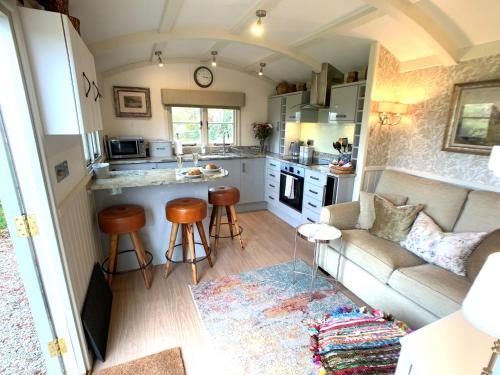 una pequeña cocina y sala de estar en una pequeña casa en Stunning Shepherds Hut with Superb Views & Fire Pit near a Superb Gastro Pub, en Lamerton