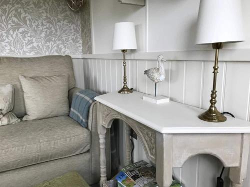 a living room with a table and a couch at Stunning Shepherds Hut with Superb Views & Fire Pit near a Superb Gastro Pub in Lamerton