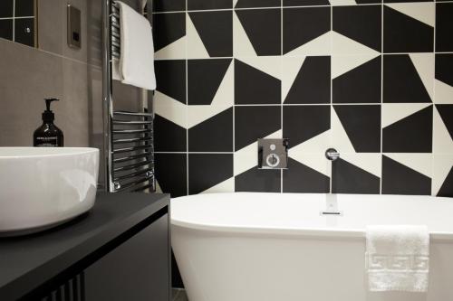 a black and white bathroom with a sink and a toilet at Leven Manchester in Manchester