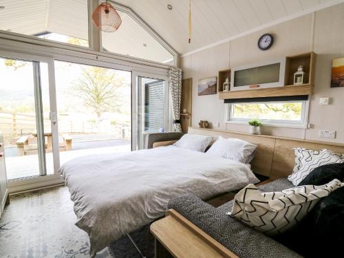 um quarto com uma cama grande e um sofá em Hillside Lodge em Rhayader