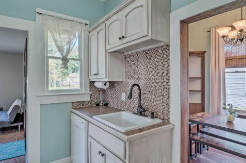 uma cozinha com um lavatório e uma janela em Lake Charles Cottage with Fireplace and Yard! em Lake Charles