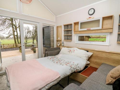 a bedroom with a bed and a tv on a wall at Woodland Escape in Rhayader