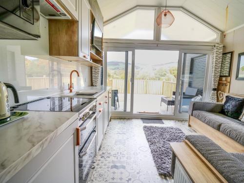 a kitchen and living room with a couch at Hares Rest in Rhayader