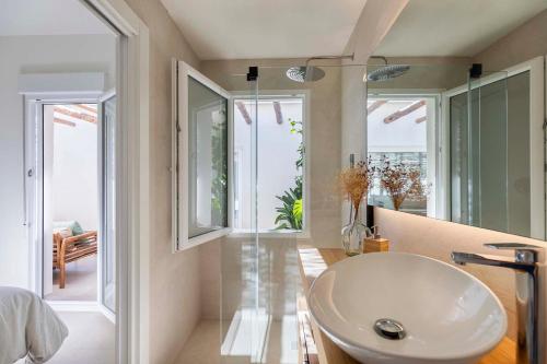 baño con lavabo blanco y puertas de cristal en Agradable casa con patio interior., en Molina de Segura