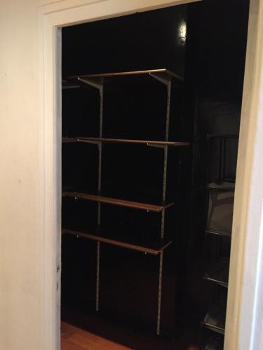 a closet with wooden shelves in a black wall at Victor Hugo 2G et sa pizza offerte in Aurillac