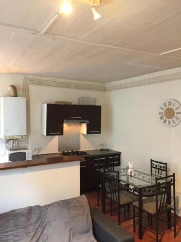 Victor Hugo 2G et sa pizza offerte في أوريلاك: غرفة معيشة مع طاولة ومطبخ