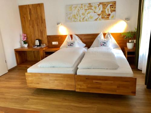 two beds in a room with wooden floors at Hotel Toscana in Interlaken